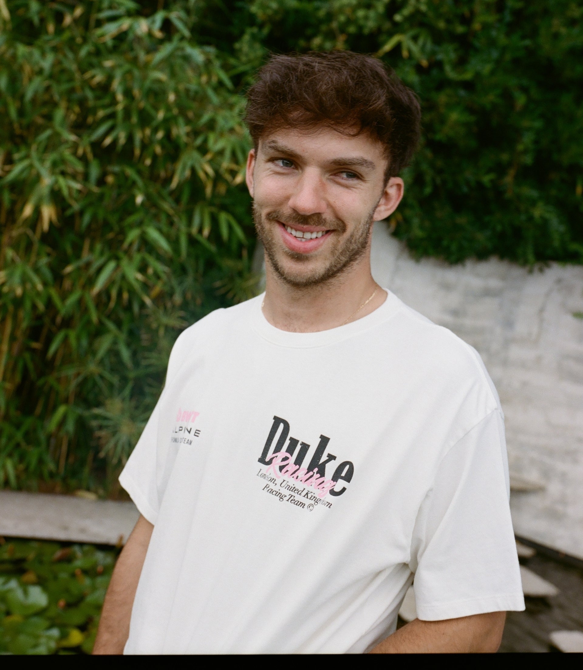 Smiling man wearing white vintage BWT Alpine Duke & Dexter T shirt outdoors