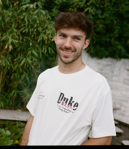 Smiling man wearing white vintage BWT Alpine Duke & Dexter T shirt outdoors