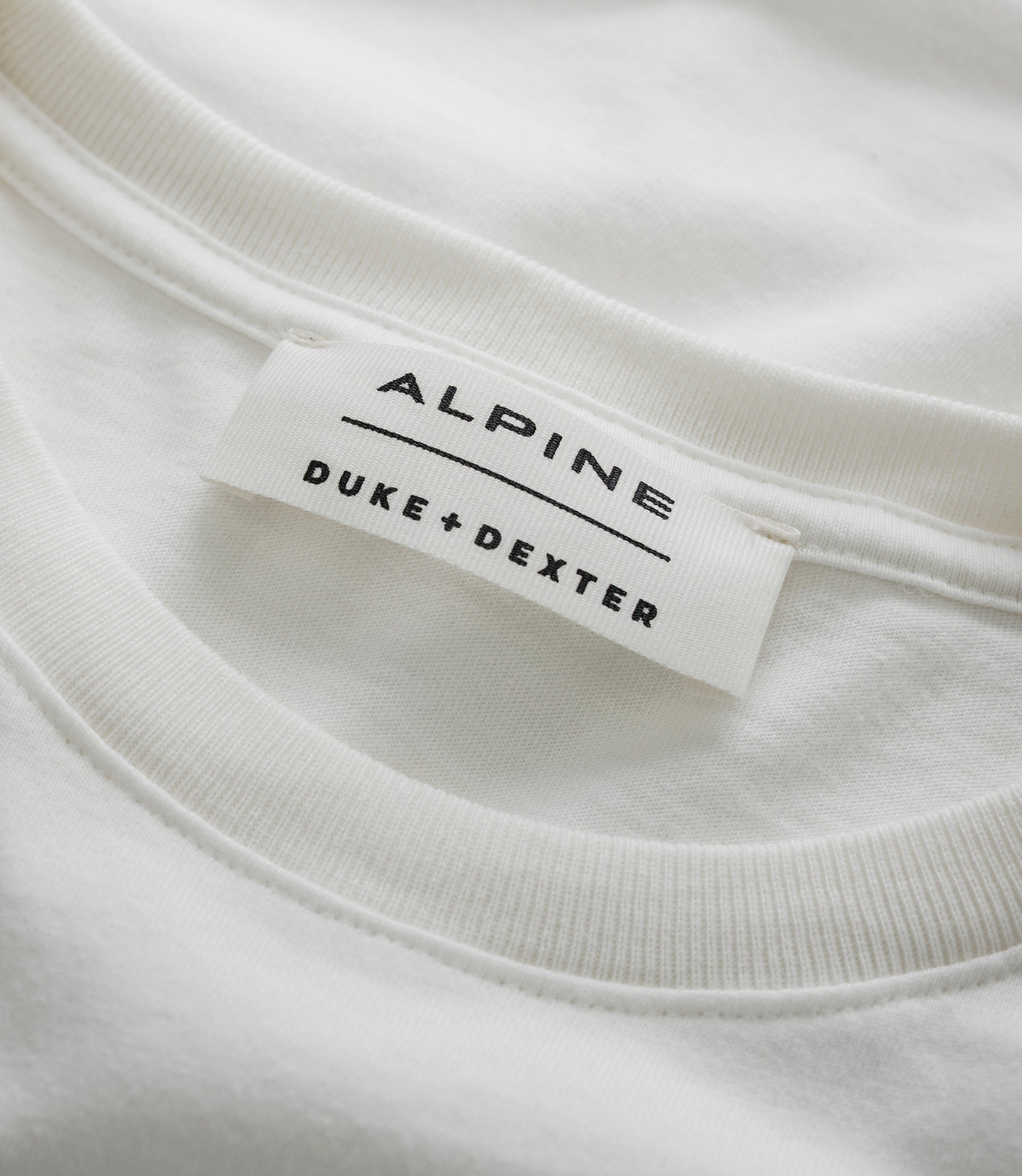 Close up of white fabric with a Duke & Dexter label on the Unisex BWT Alpine vintage T shirt