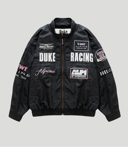 Black trackside bomber jacket with racing patches and a central zipper, Duke Racing and Alpine logos.