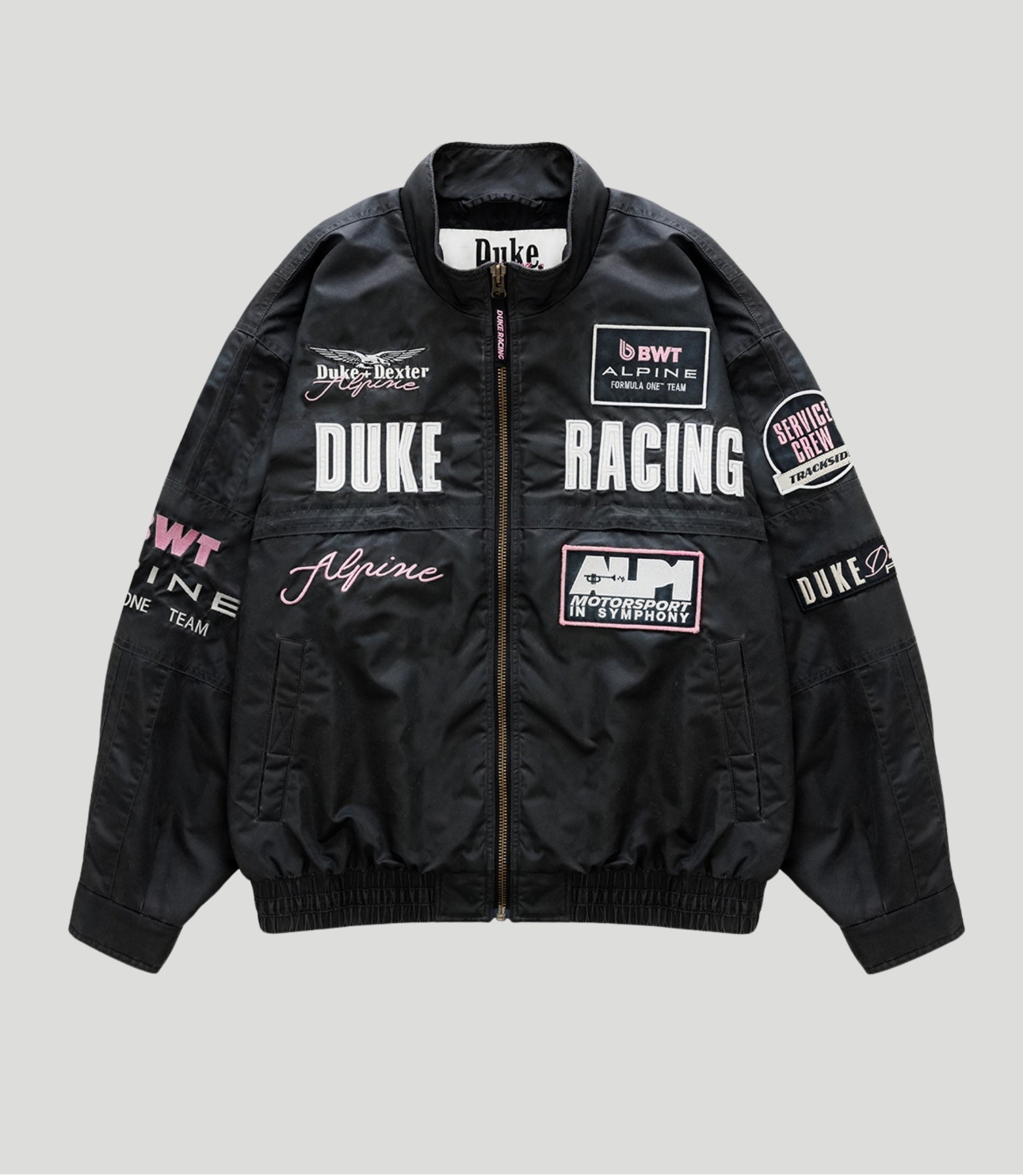 Black trackside bomber jacket with racing patches and a central zipper, Duke Racing and Alpine logos.