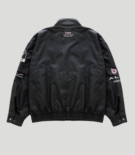 Back view of black trackside jacket with pink BWT Alpine logo and Alpine Formula One Team text.