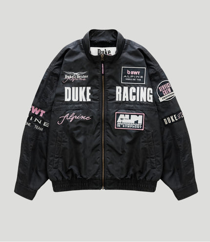 Black trackside bomber jacket with racing patches and a central zipper, Duke Racing and Alpine logos.