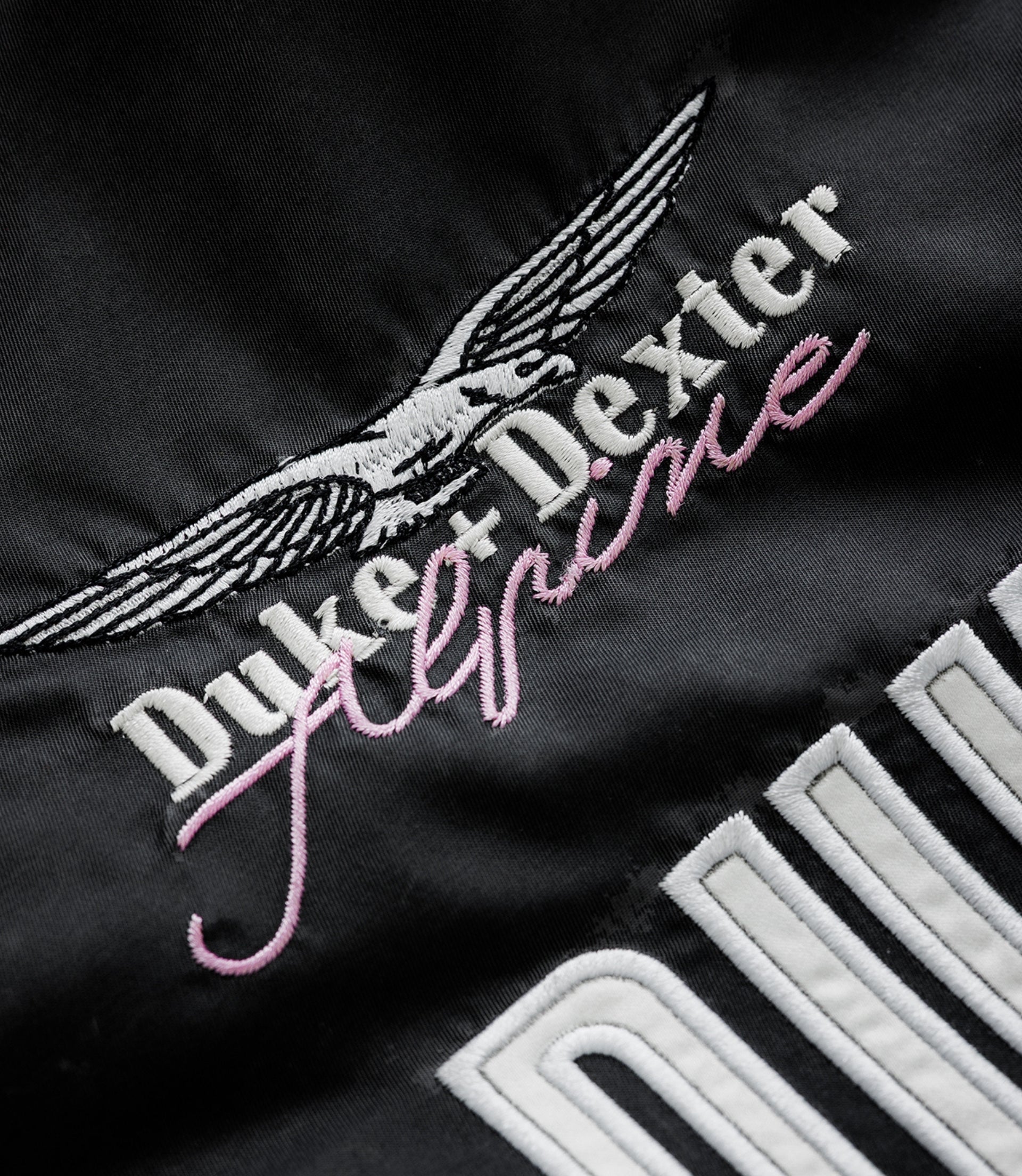 Wing emblem and Alpine branding in white on black fabric of the jacket