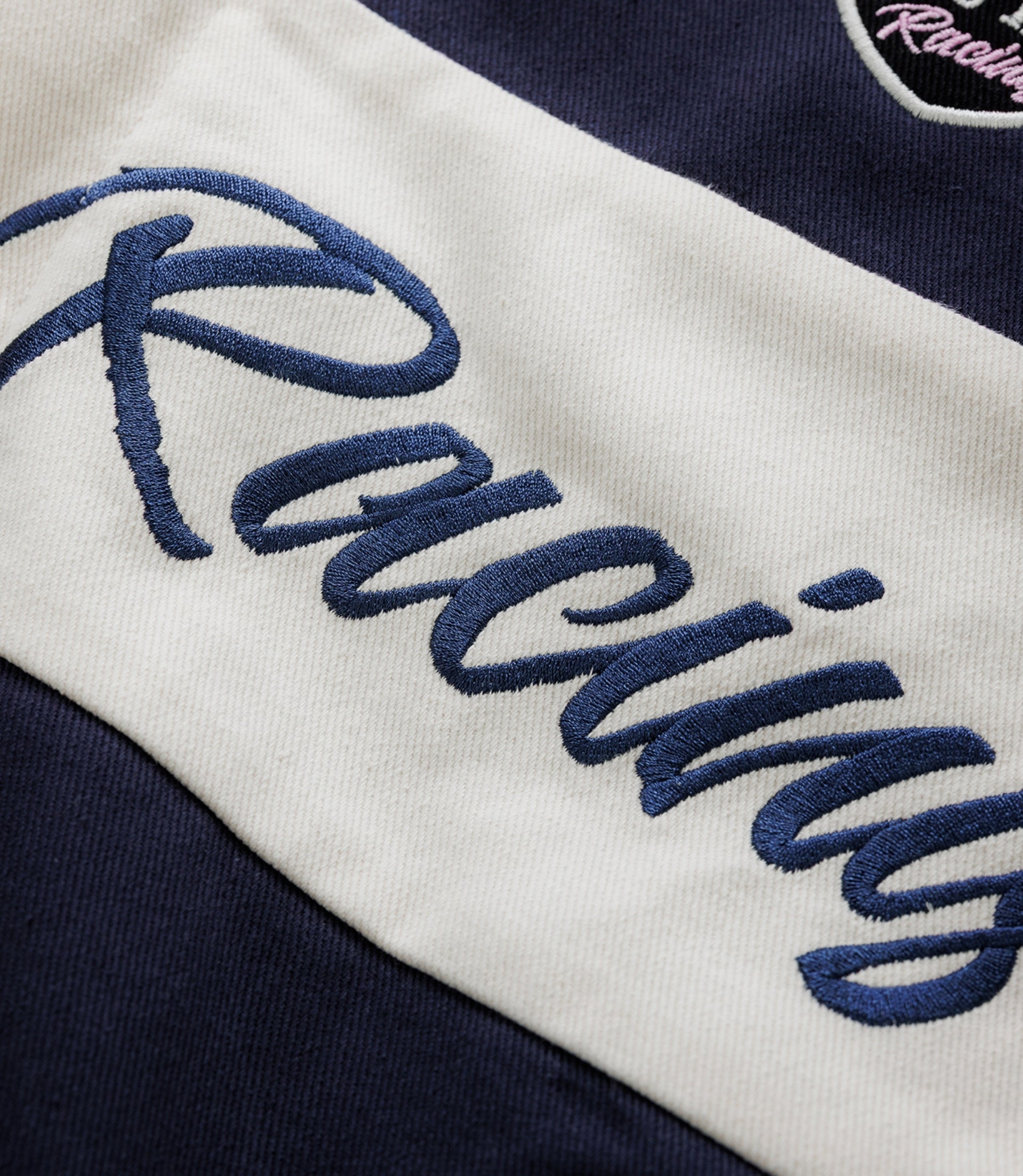 Embroidered white wings and Duke & Dexter script on navy jacket