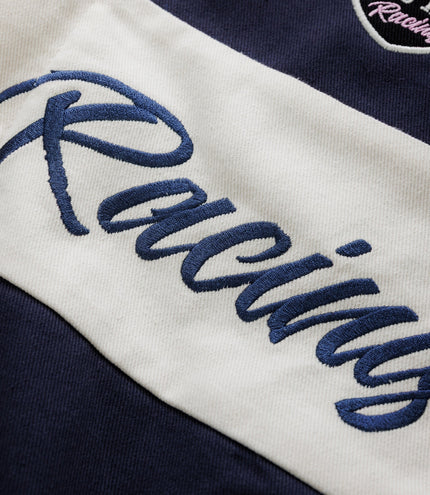 Embroidered white wings and Duke & Dexter script on navy jacket