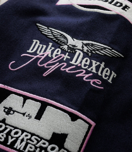 Duke & Dexter racing patch outlined in pink on navy fabric with finish line graphic