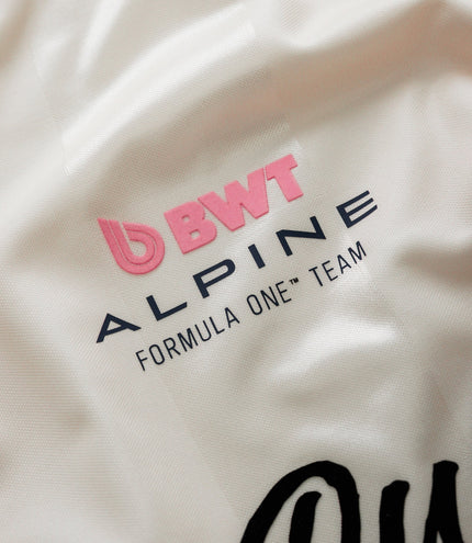 White fabric close up with pink BWT Alpine Formula One Team logo