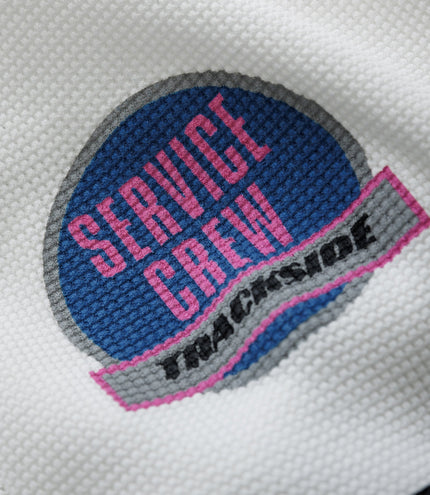 Close up of white waffle fabric featuring a blue Alpine patch and a pink Duke & Dexter label on black background